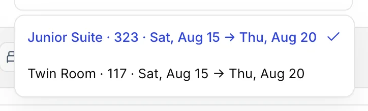 The room-line select at the top of the dialog, open on two options: Junior Suite 323 Sat Aug 15 to Thu Aug 20, and Twin Room 117 Sat Aug 15 to Thu Aug 20.
